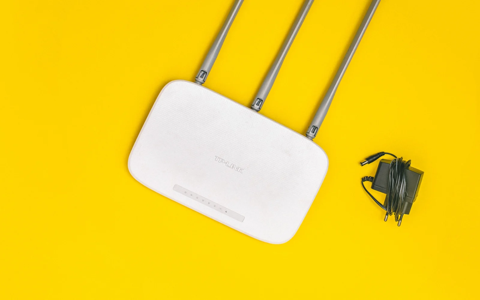 Router s anténami na žltom pozadí